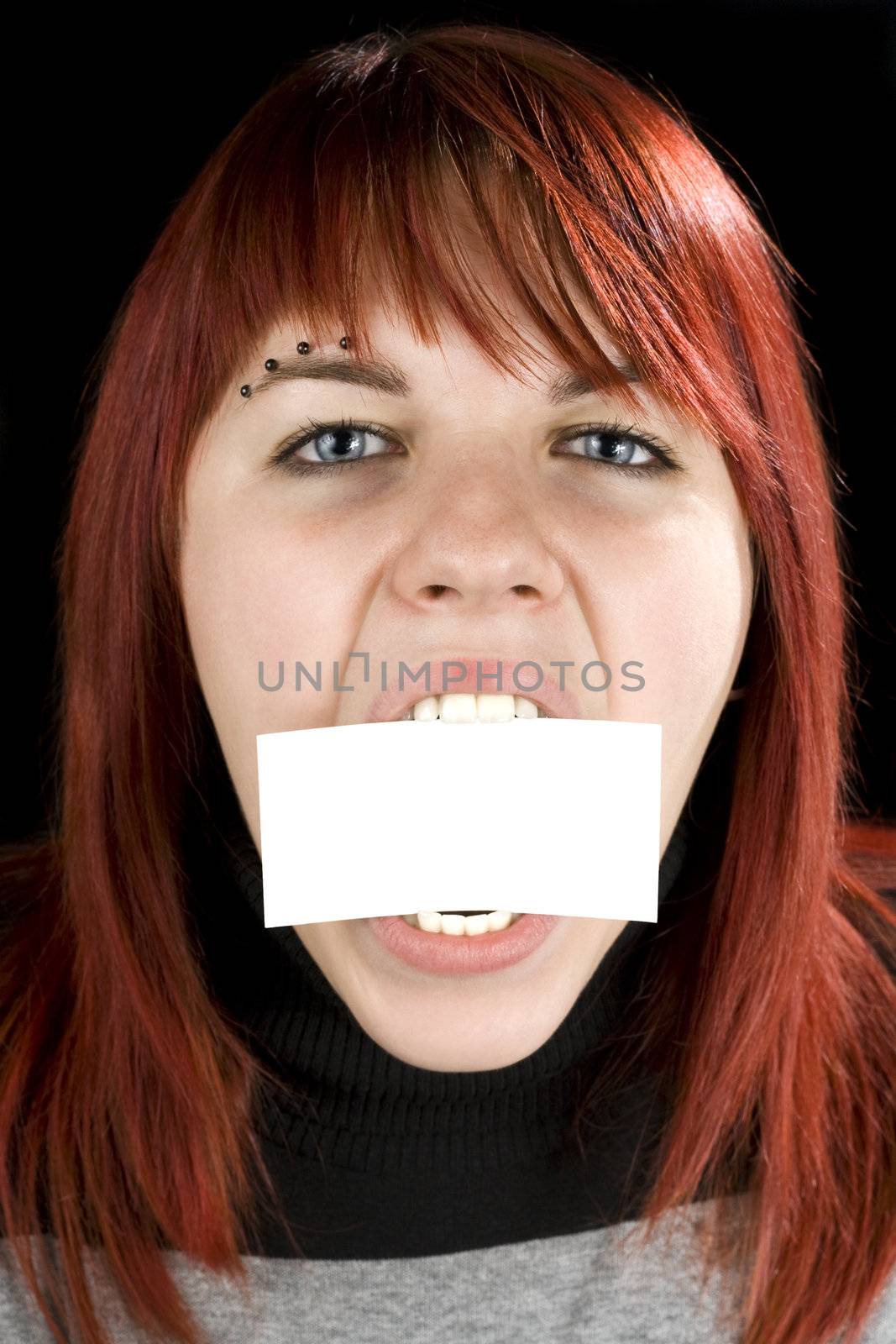 Redhead girl aggressively biting or eating a blank greeting card. Concept expresses nutrition or eating disorder problems.

Studio shot.

Studio shot.