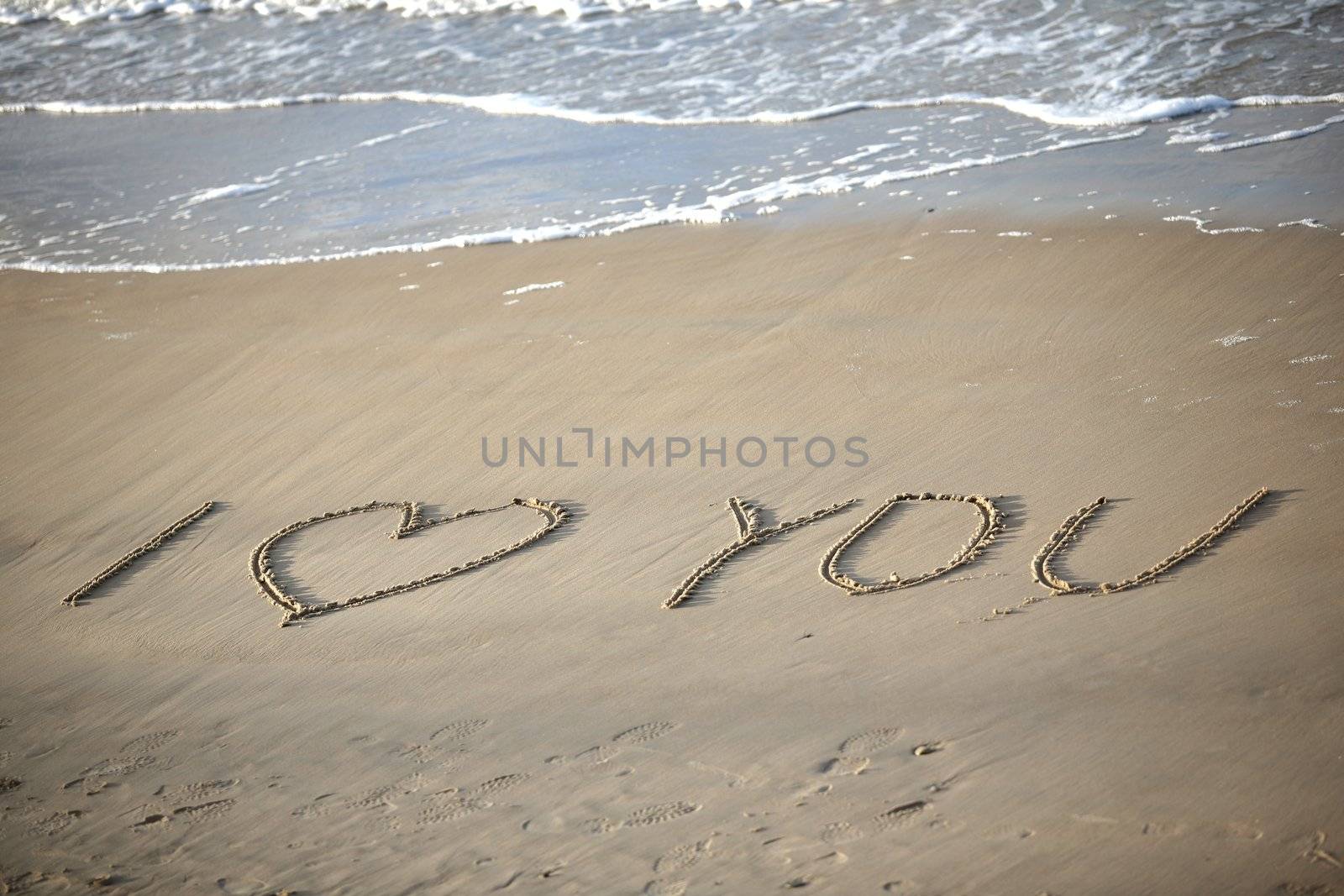 Words about love written on wet sand