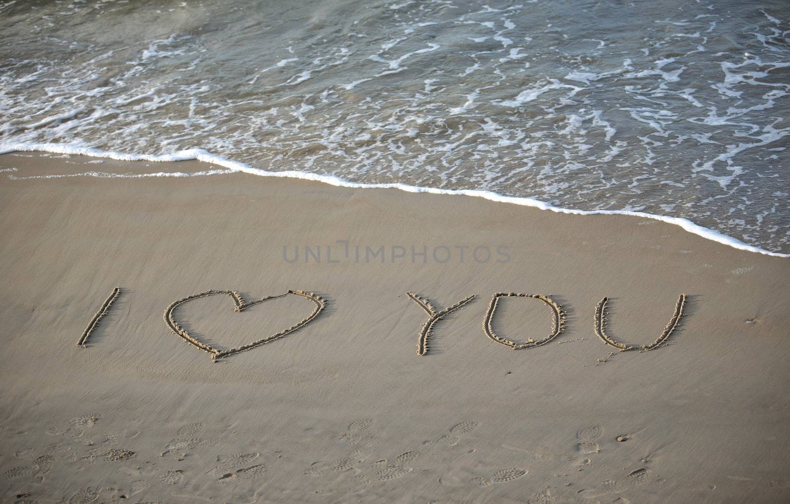 Words about love written on wet sand