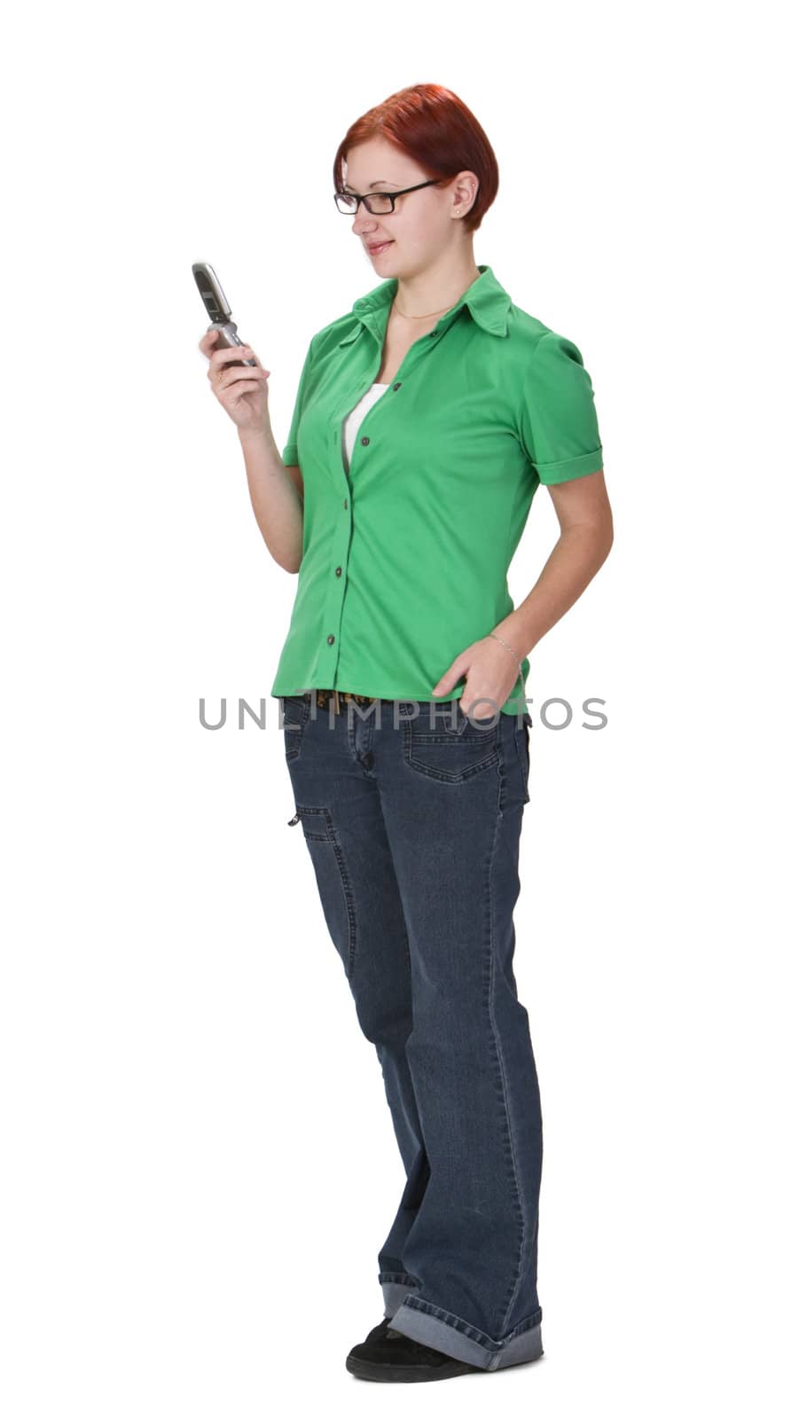 Smiling redheaded girl using a mobile phone while is standing up.