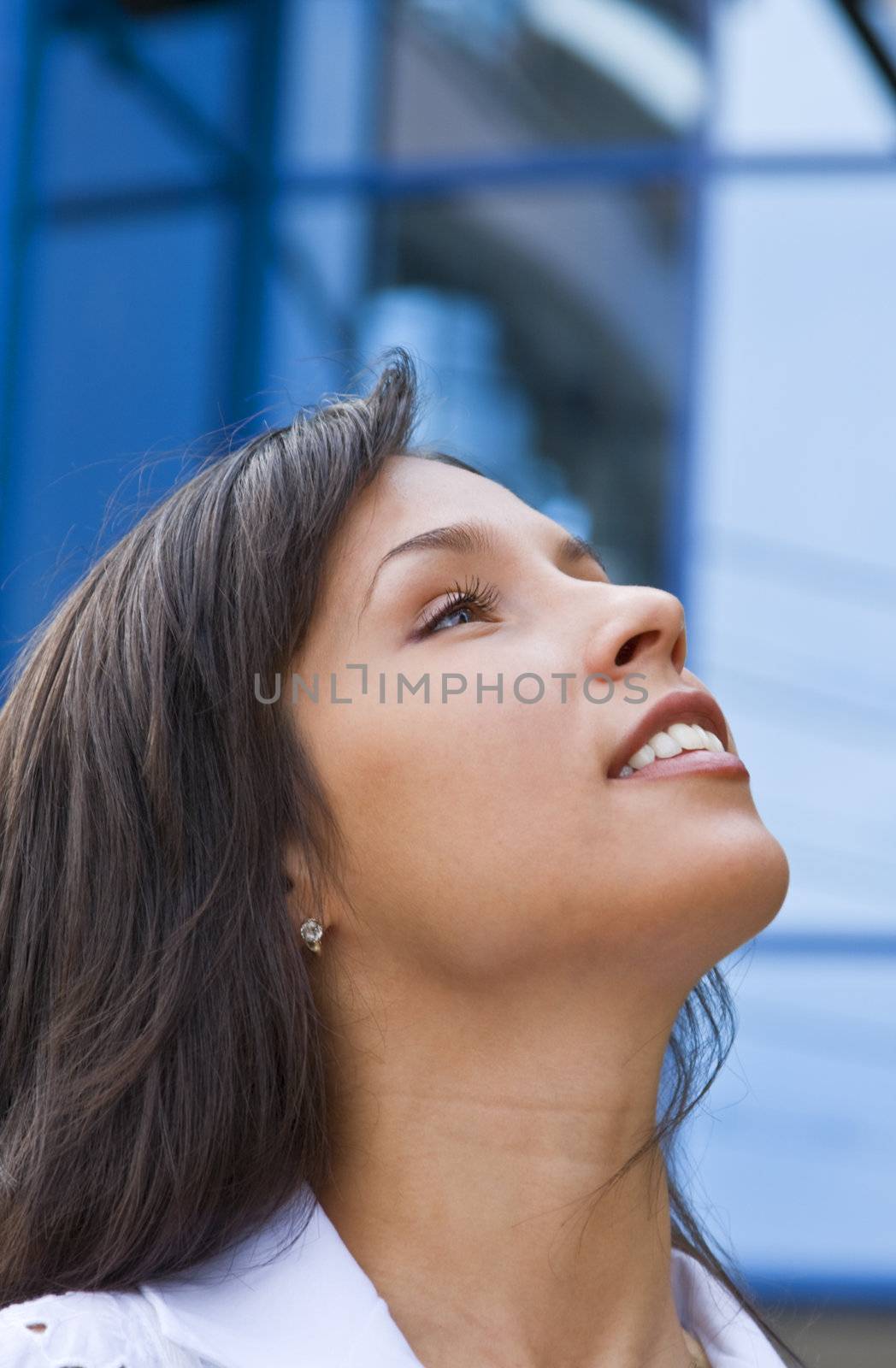 Portrait of an optimistic young brunette in front of a corporate building.
