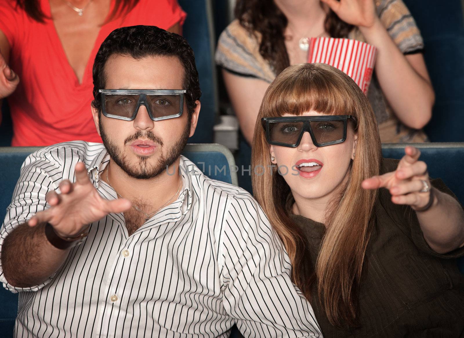 Amazed Caucasian couple with 3D glasses in theater seats