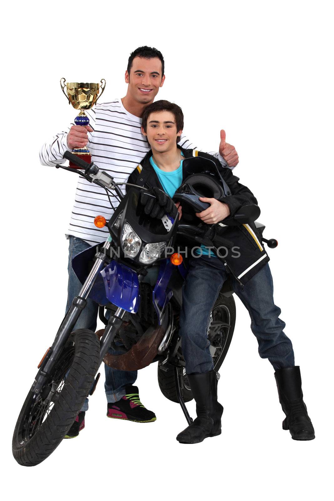 Father and son with a motorbike trophy by phovoir