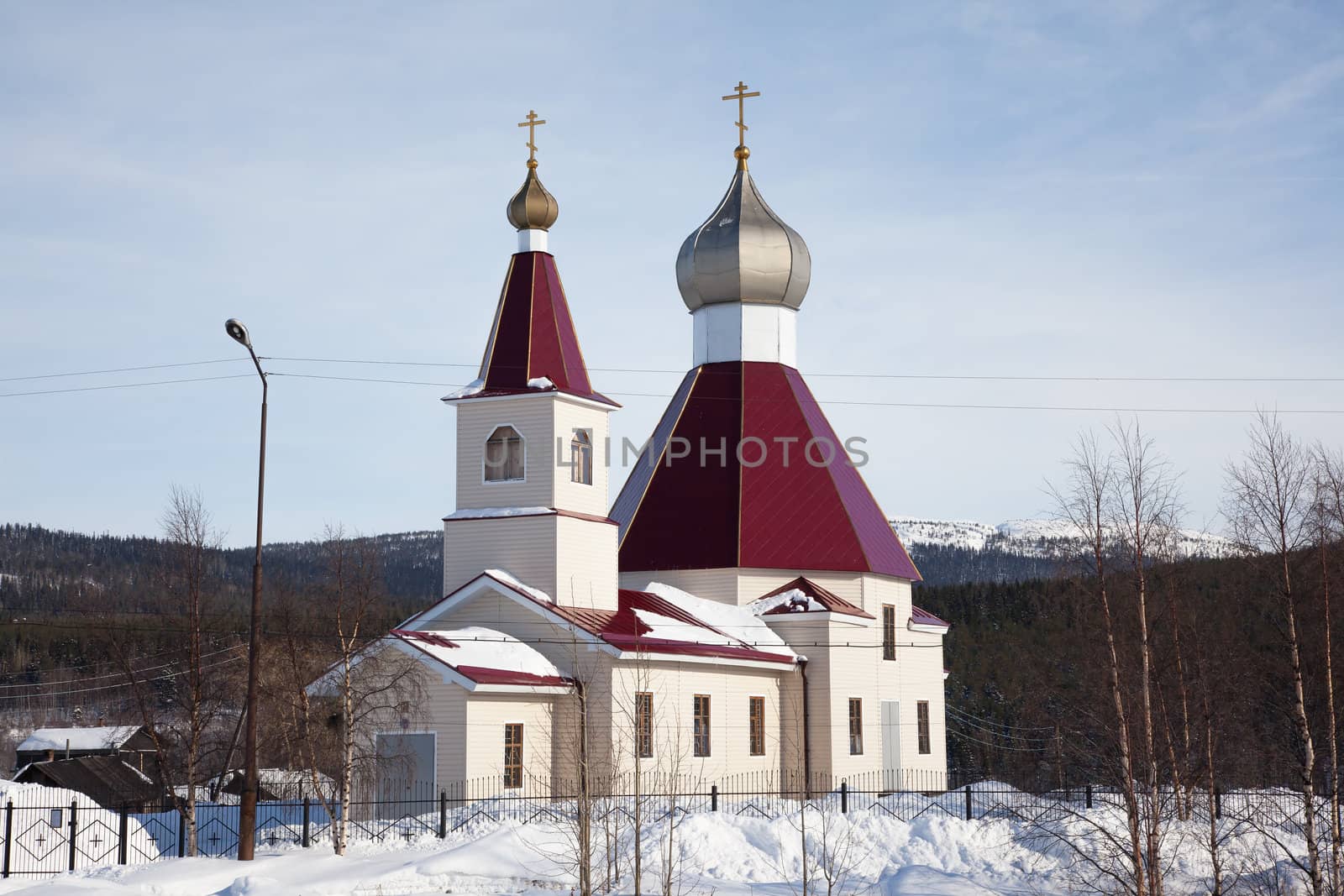 The new building of the Orthodox Church in the background of the winter forest
