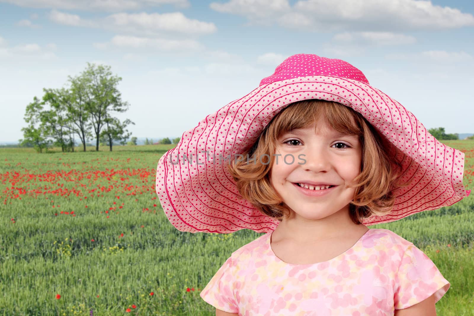 beautiful little girl and green wheat field