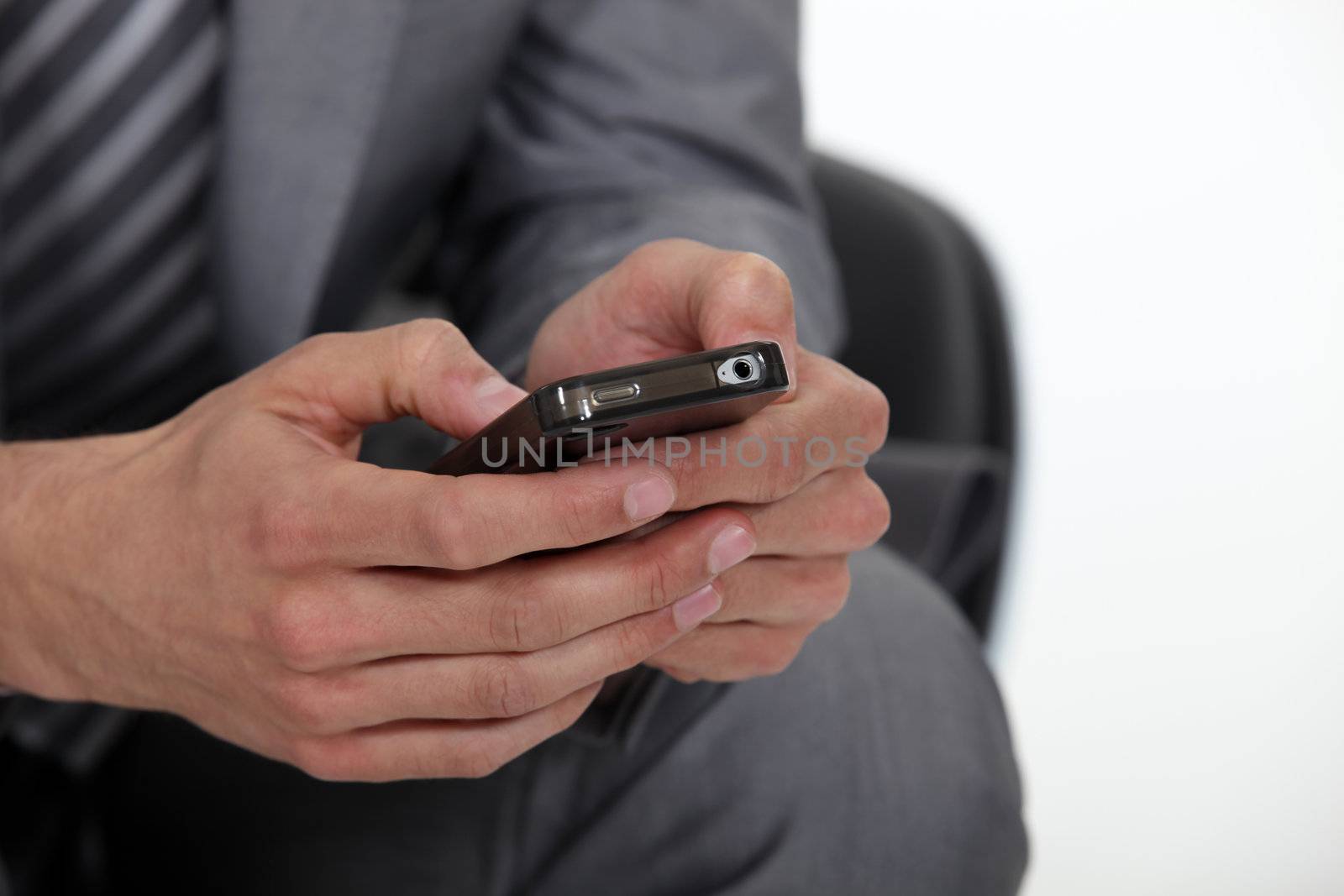 A cropped picture of a businessman texting. by phovoir