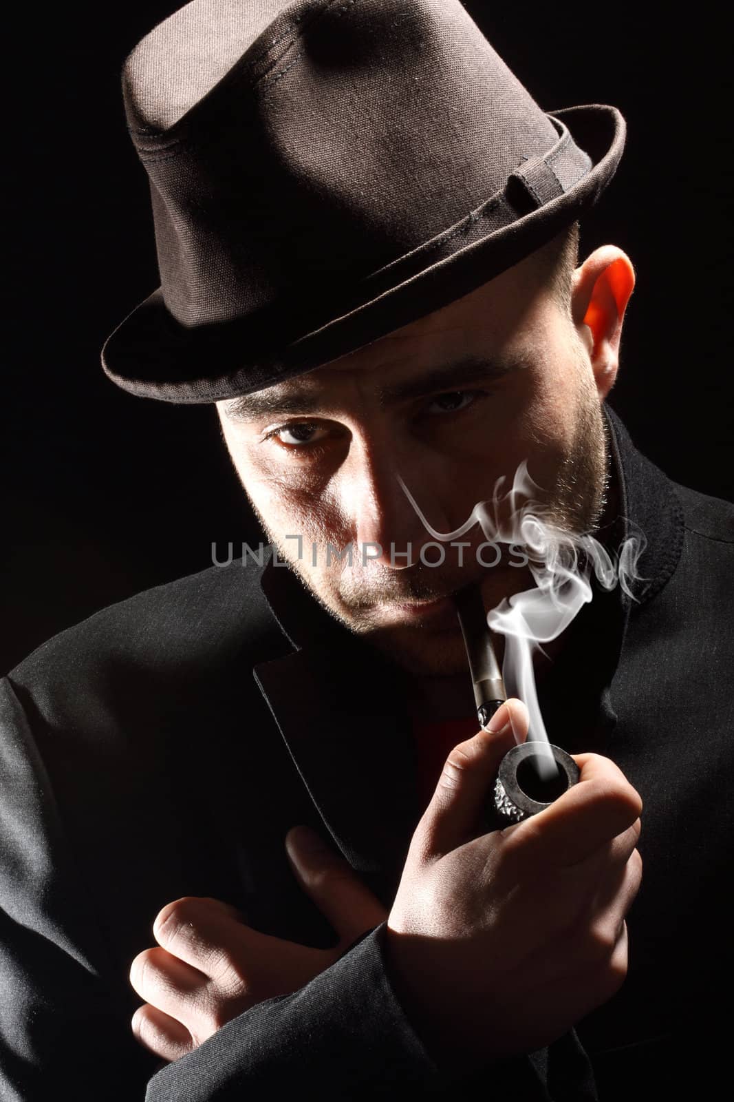 close portrait of a pipe smoker on a black background