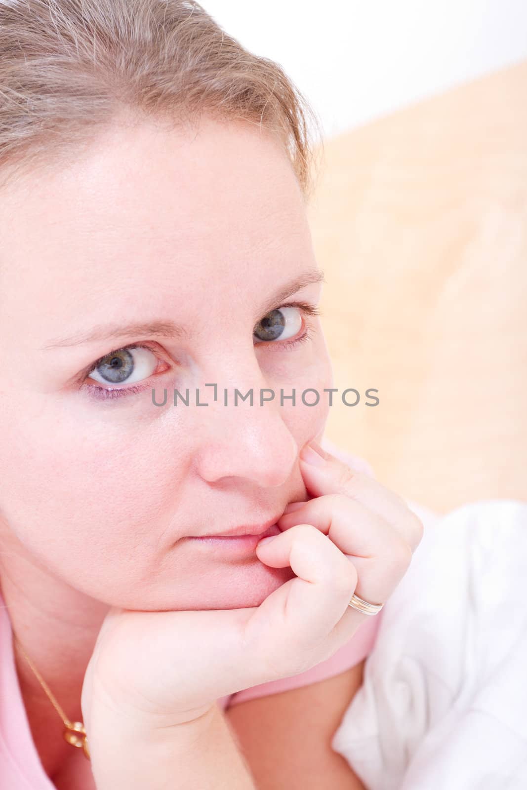 Young female woman resting on her hand and looking at camera.