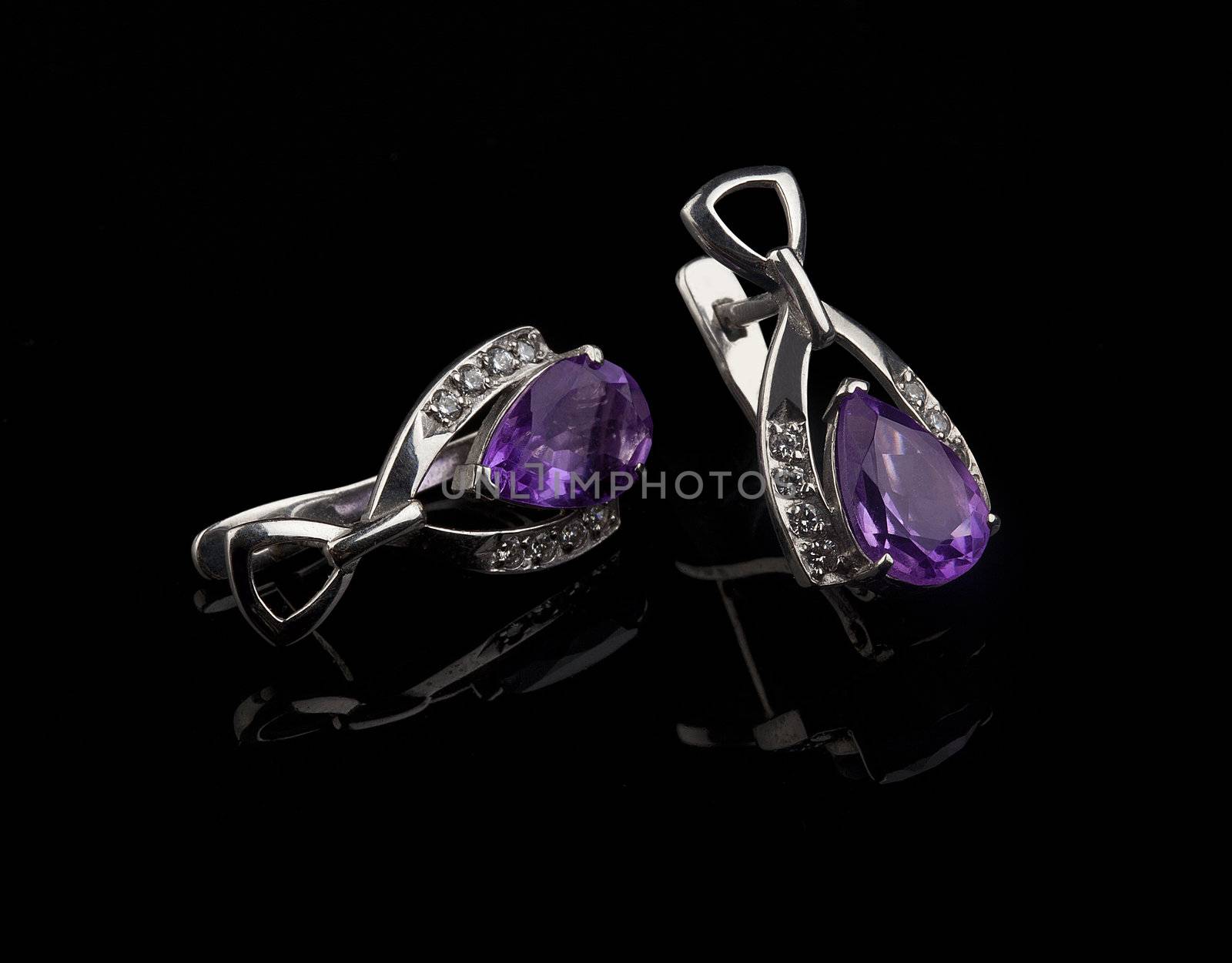 Silver ear-ring with amethyst on the black background