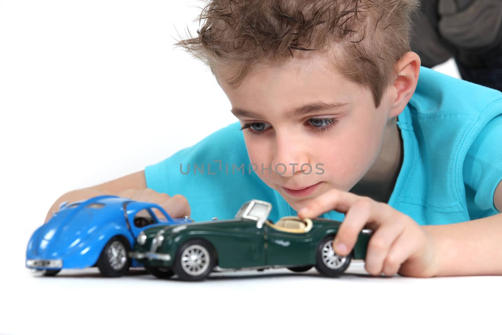 little boy playing with cars by phovoir