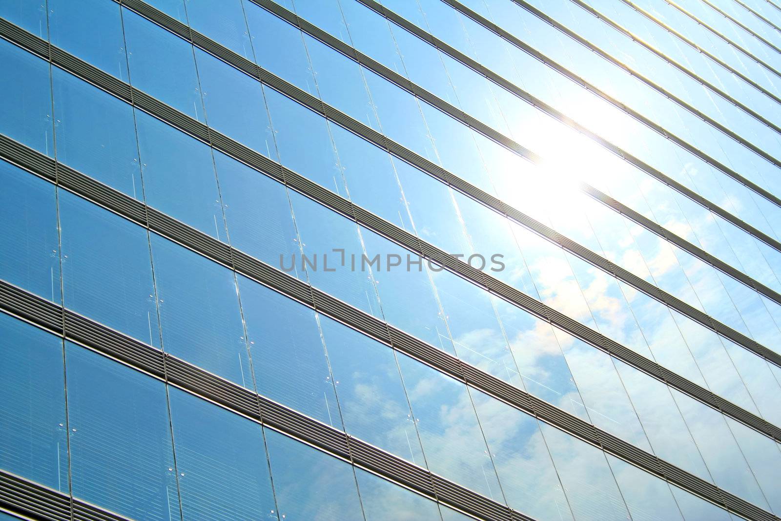 A glass storefront reflecting a bright blue sky.