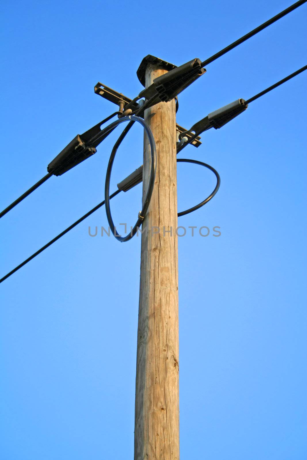 A power supply line in front of a bright blue sky.