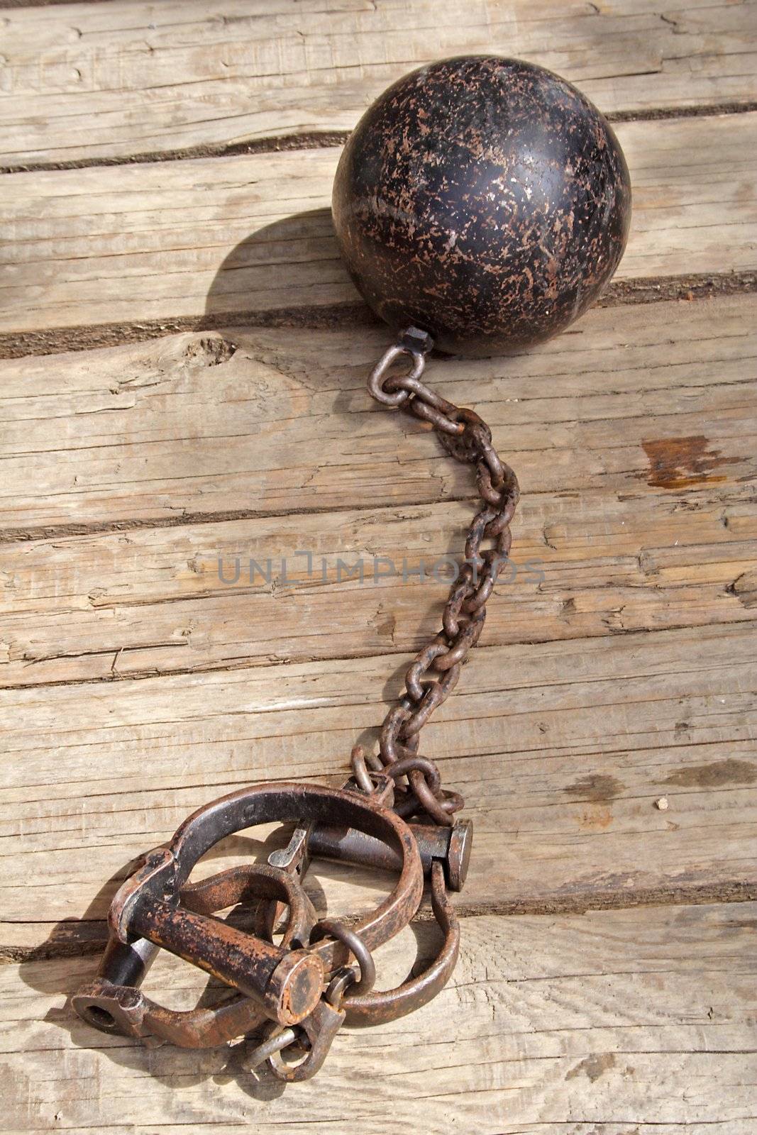 An iron chain from the middle-ages lying on planks.