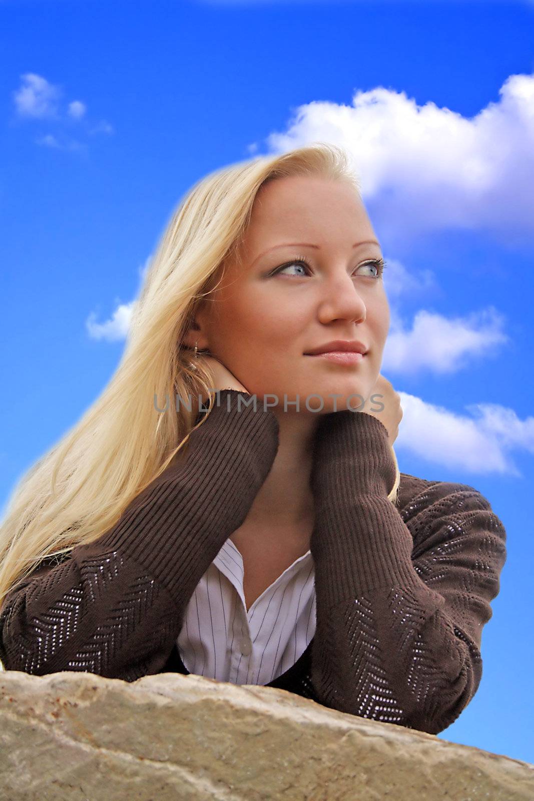 A portrait of a young beautiful blonde woman infront of a bright blue sky.
** Note: Slight blurriness, best at smaller sizes.
