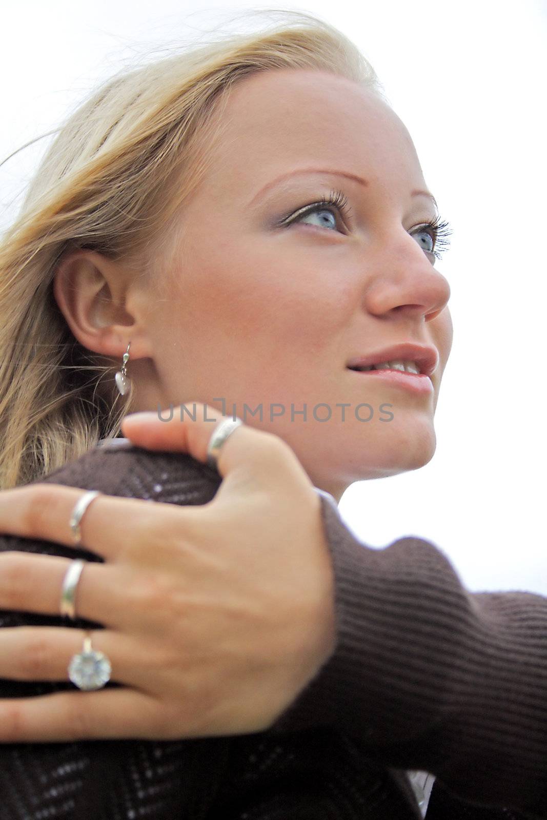 A young handsome woman hugging herself and looking away.
