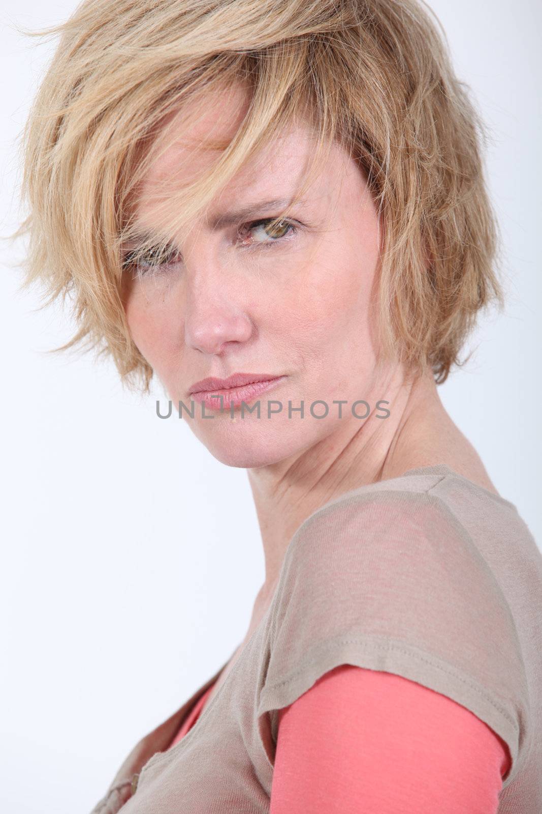 50 years old woman with tousled hair looks anger or in trouble by phovoir