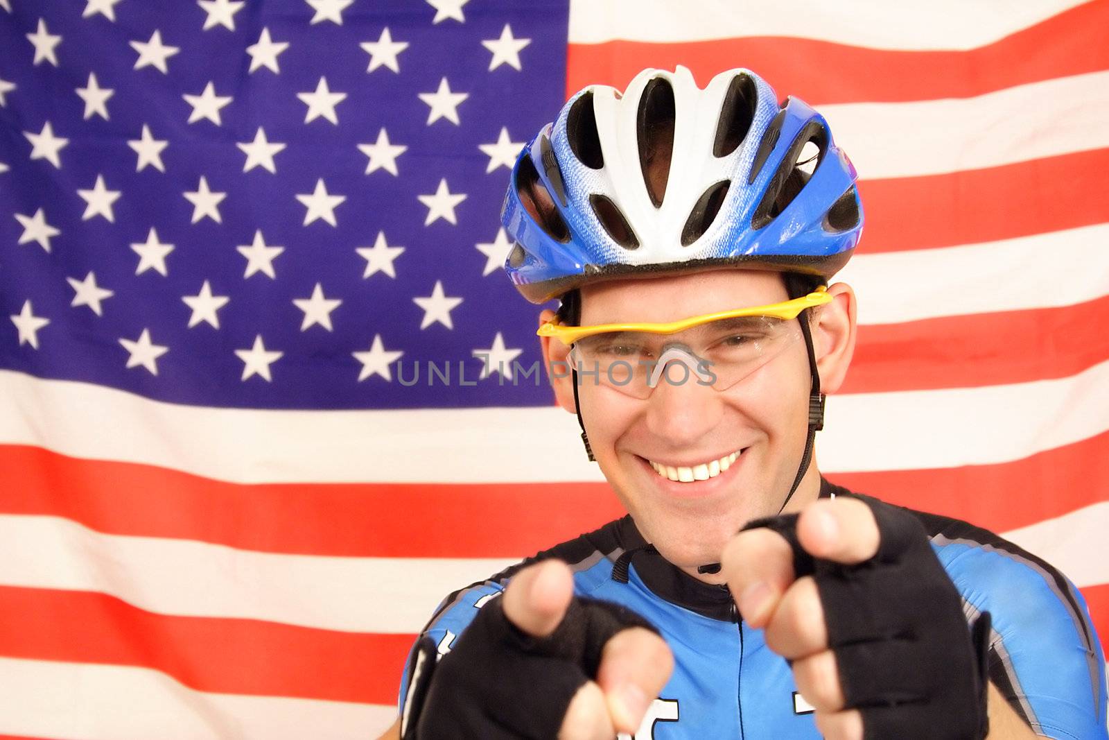 An US pro cyclist in optimistic mood in front of the flag of the United States of America.