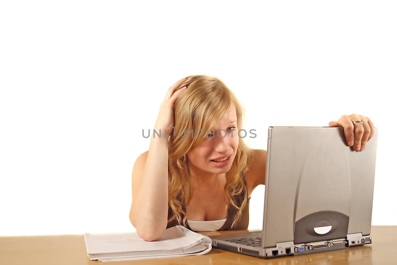 A stressed student in front of her notebook computer. All isolated on white background.