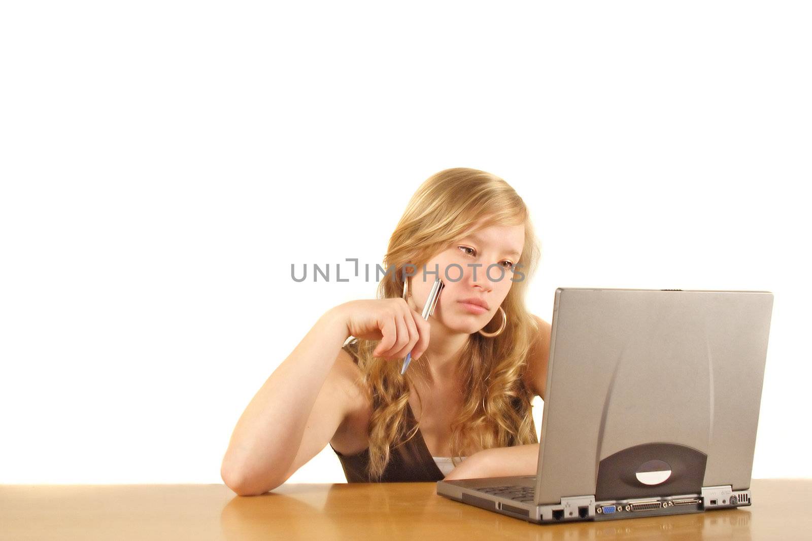 A young handsomewoman sitting in front of her notebookcomputer bred. All isolated on white background.