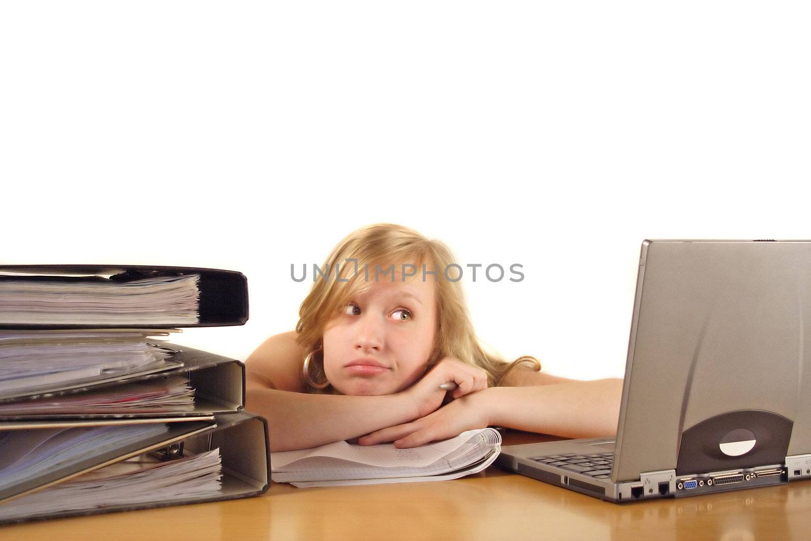 A young handsomewoman sitting in front of her notebook computer bored. All isolated on white background.