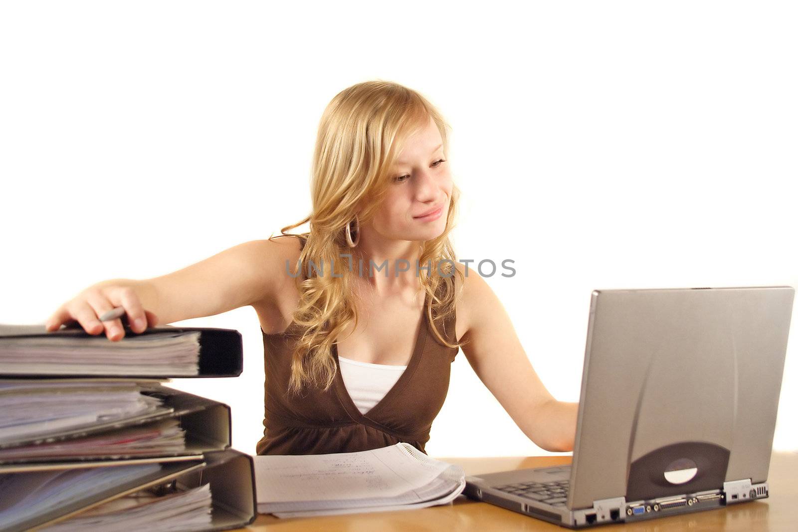 A young ambitious woman in front of her notebook computer. All isolated on white background.