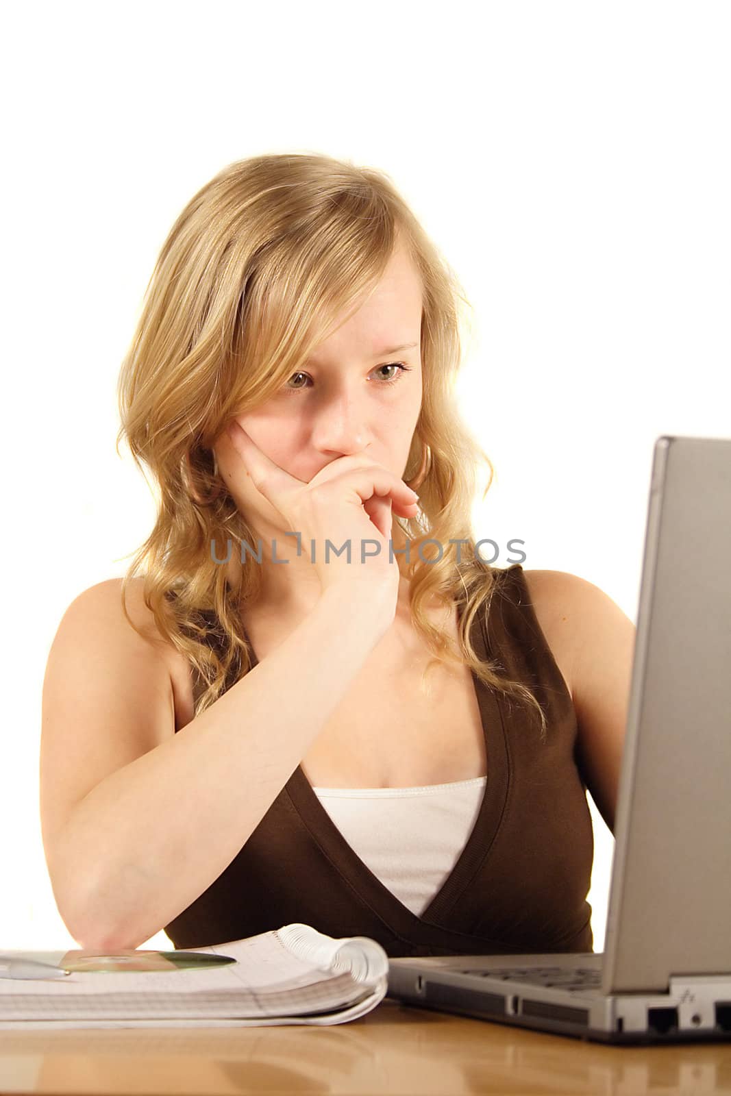 A young ambitious woman in front of her notebook computer. All isolated on white background.