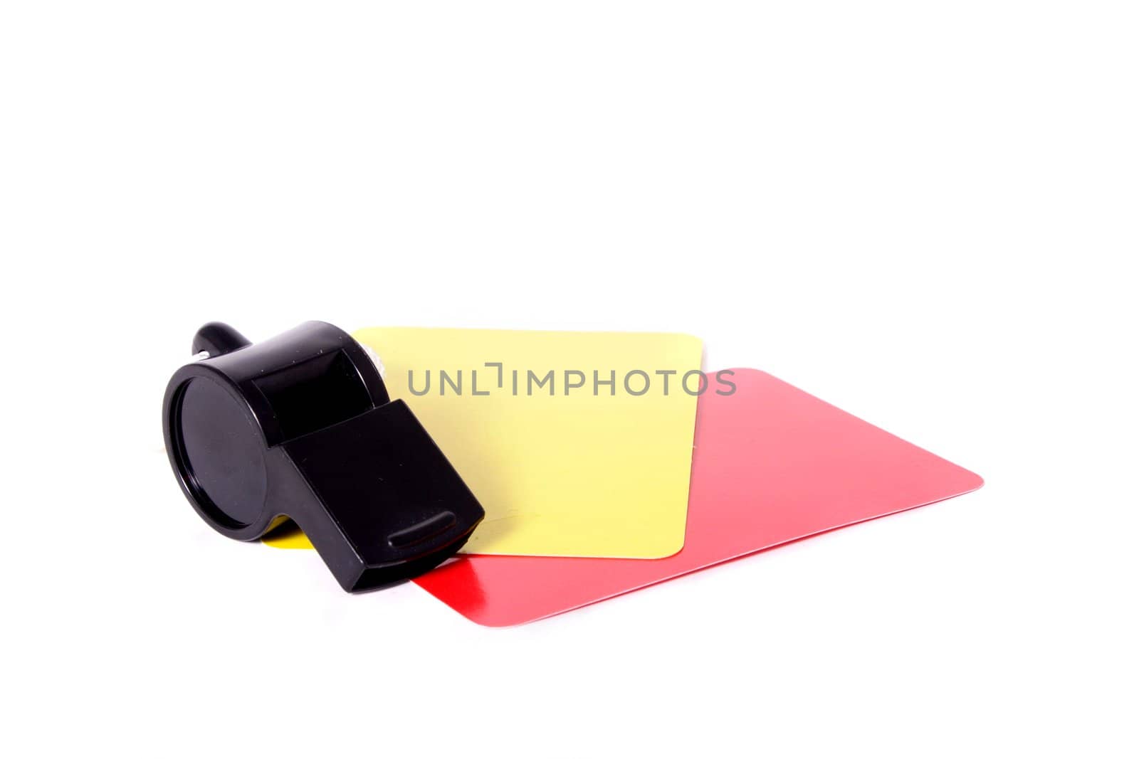 A yellow and red card lying next to a whistle. All isolated on white background.
