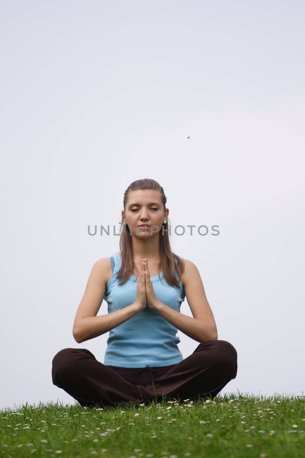 A handsome young woman concentrates on a green meadow.