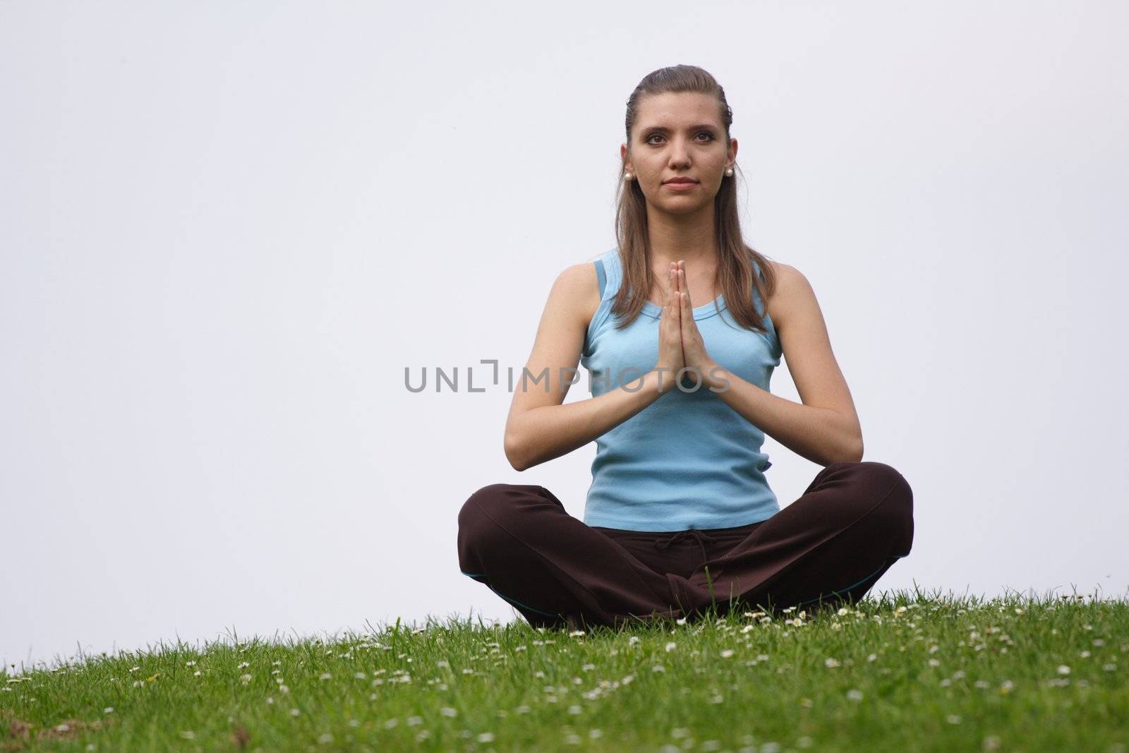 A handsome young woman concentrates on a green meadow.