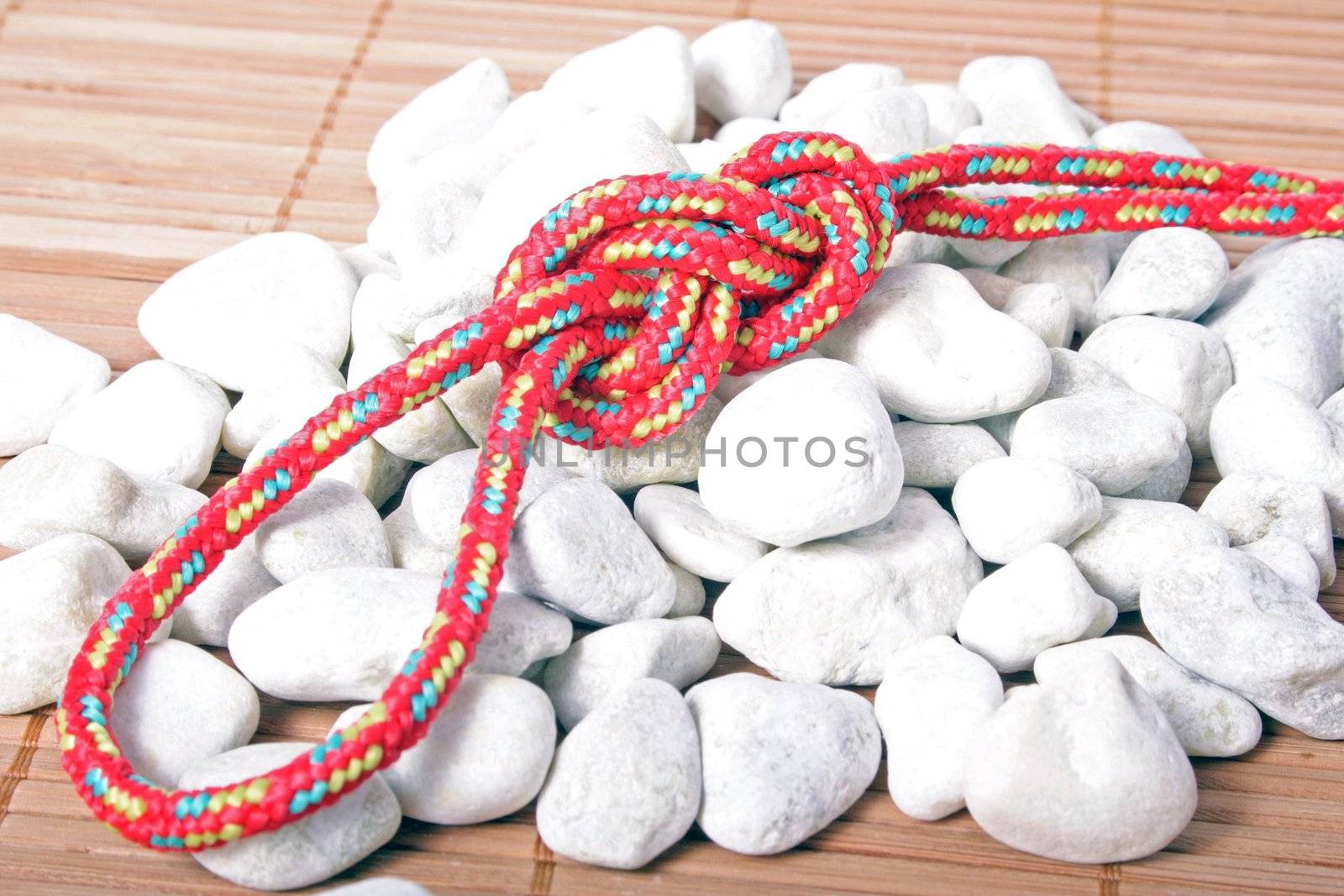 A fine knotted figure of eight loop lying on a pile of stones.