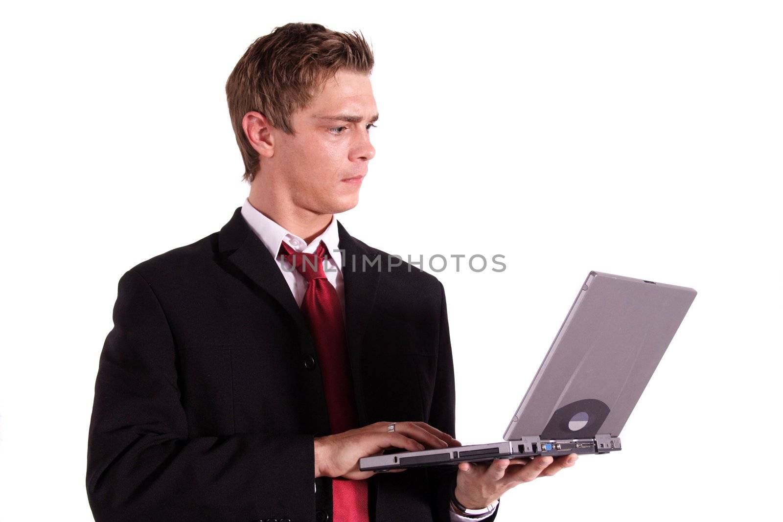 A motivated businessman working on his notebook computer. All isolated on white background.