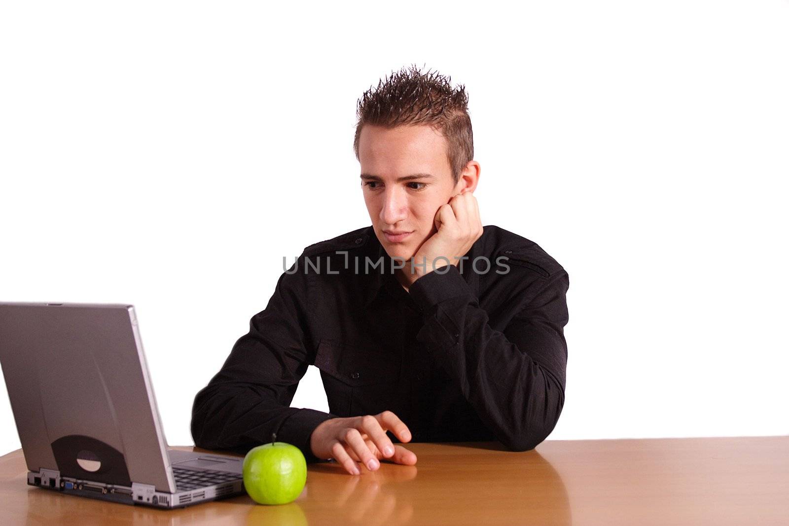 A young bored man is sitting at his workplace. All isolated on white background.