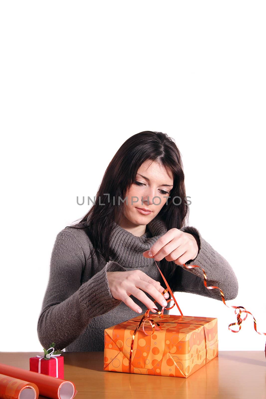 A handsome young woman wrapping presents. All isolated on white background.