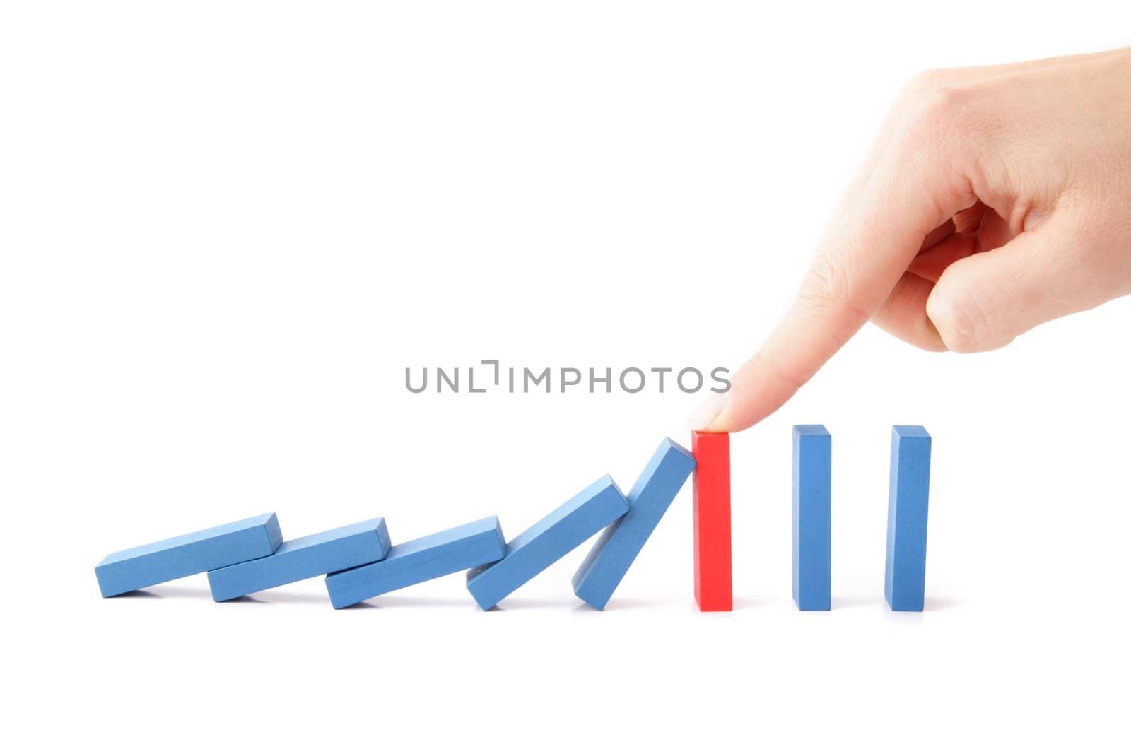 A human hand intervenes a chain reaction of a domino game. All isolated on white background.