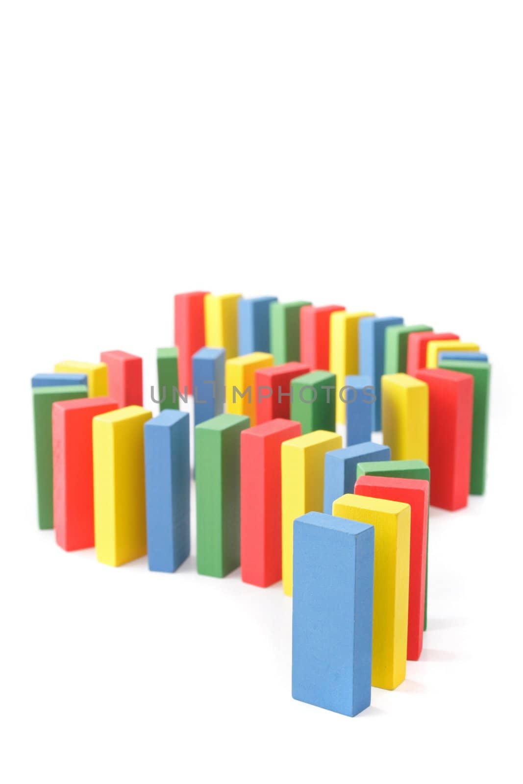 Several multicolored dominoes standing one after another. All isolatoed on white background.