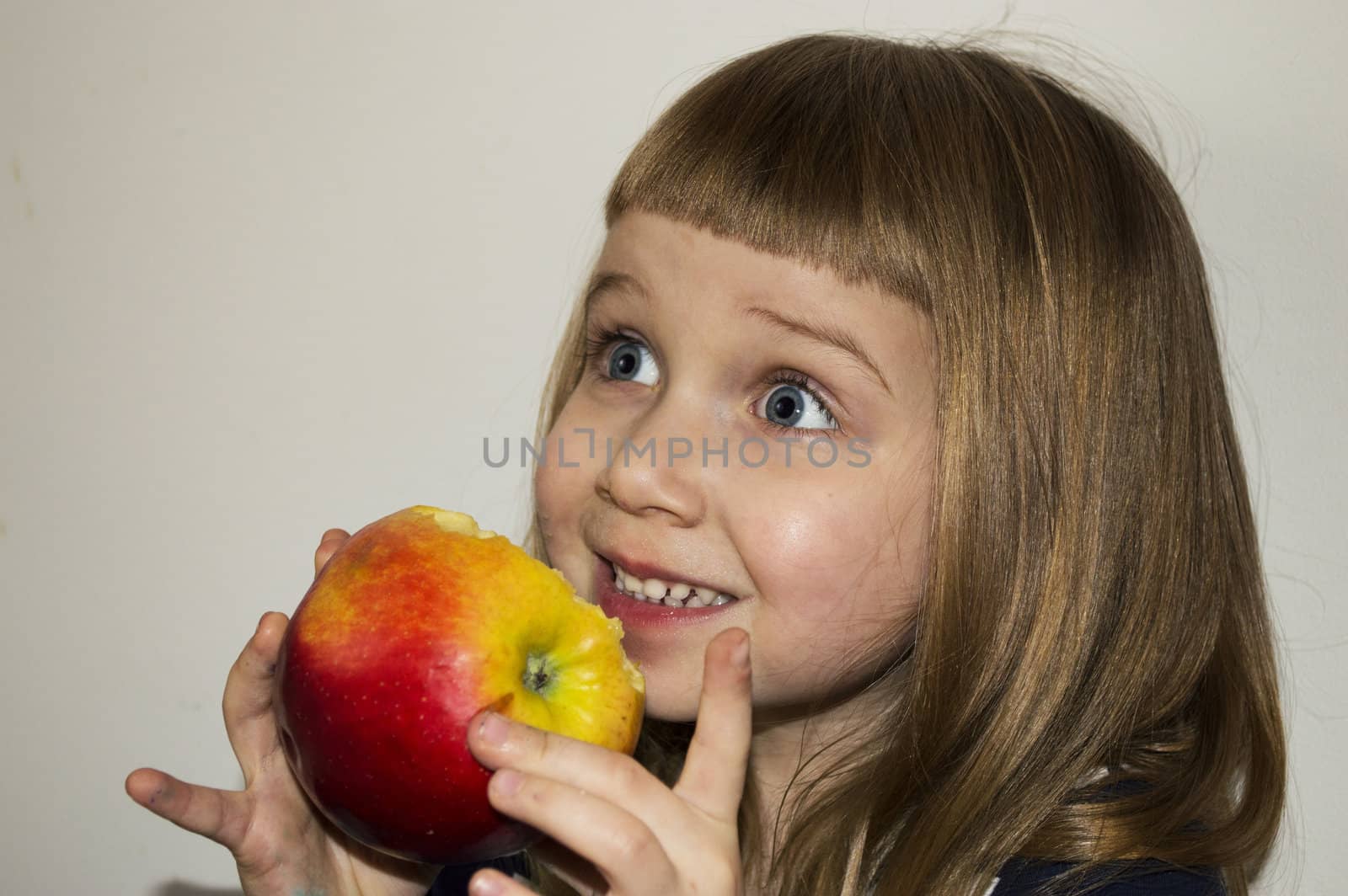 girl is smileing and eating apple