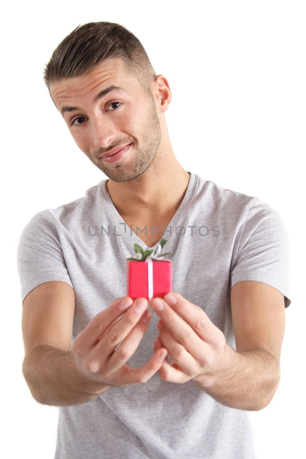A handsome man handovers a small present. All isolated on white background.
