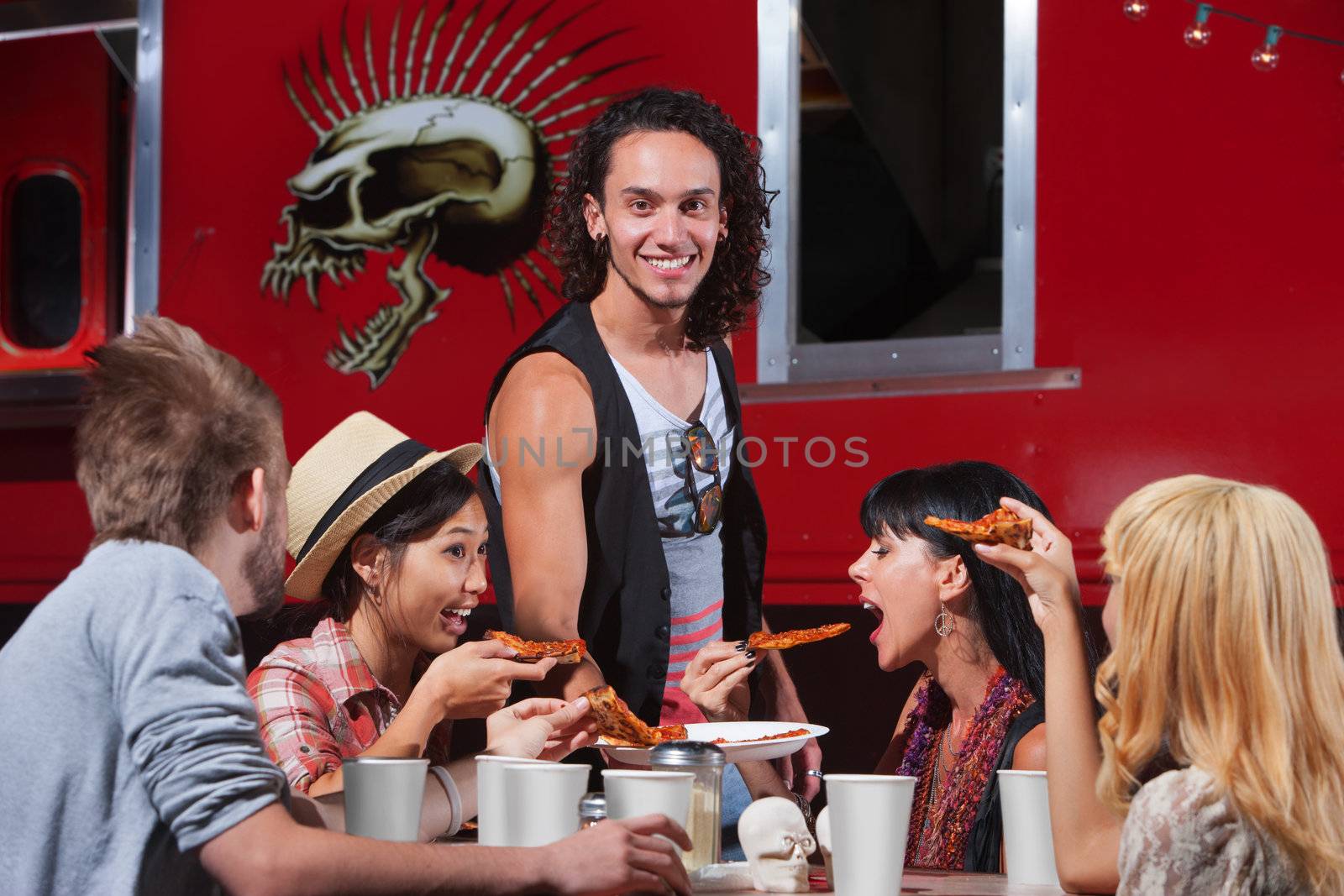 Hungry friends sharing slices of pizza at cafe