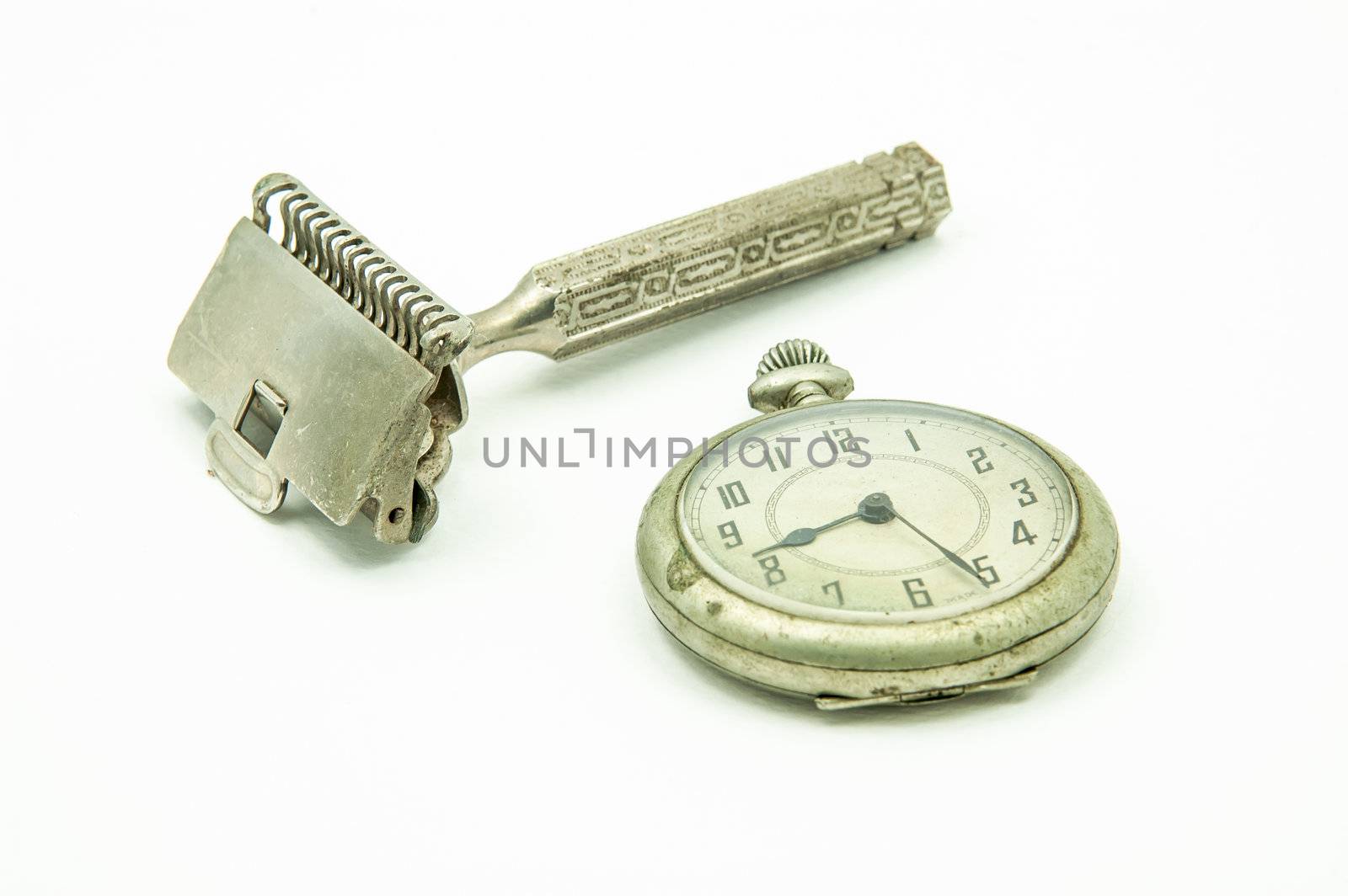 Old pocket watch and shaving device at the studio. Men accessories