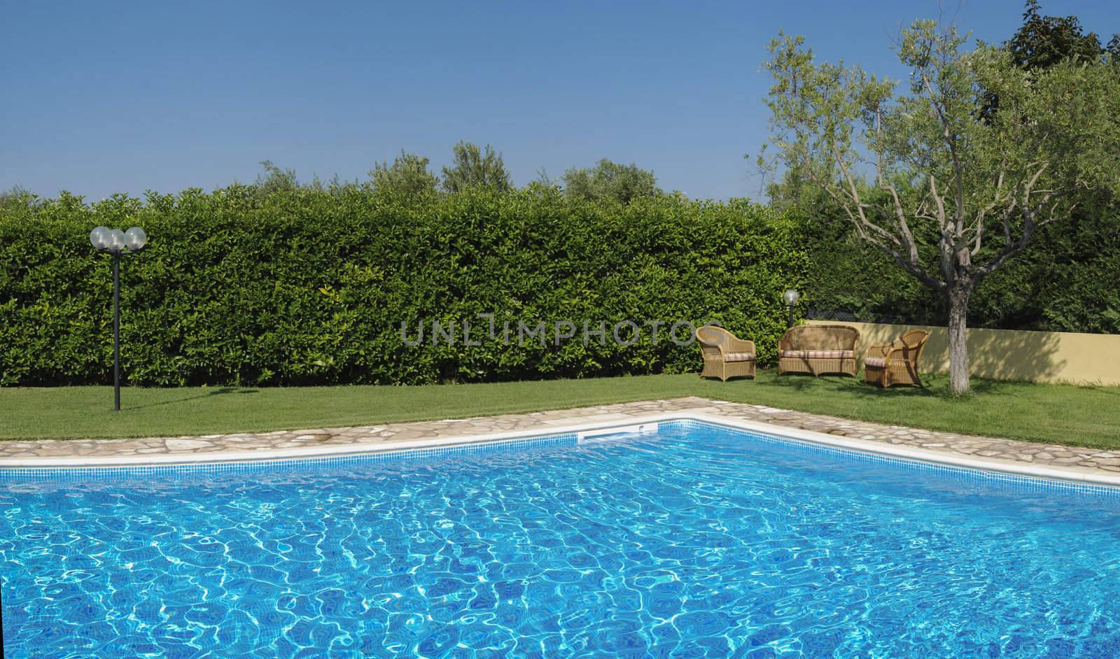 A sitting area with a pool on a sunny day