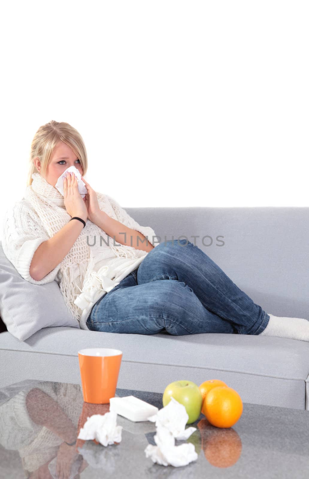 An attractive young woman feeling very bad while sitting at home on her couch.