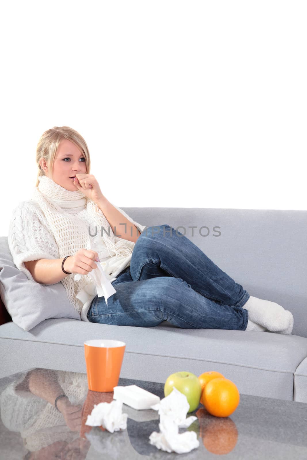 An attractive young woman feeling very bad while sitting at home on her couch.