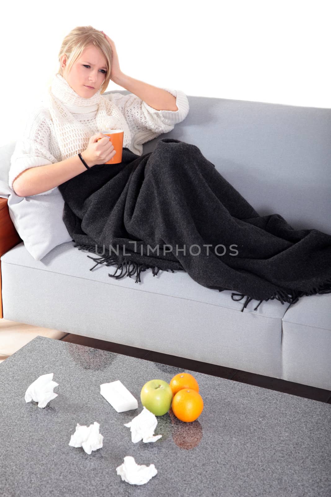 An attractive young woman feeling very bad while sitting at home on her couch.