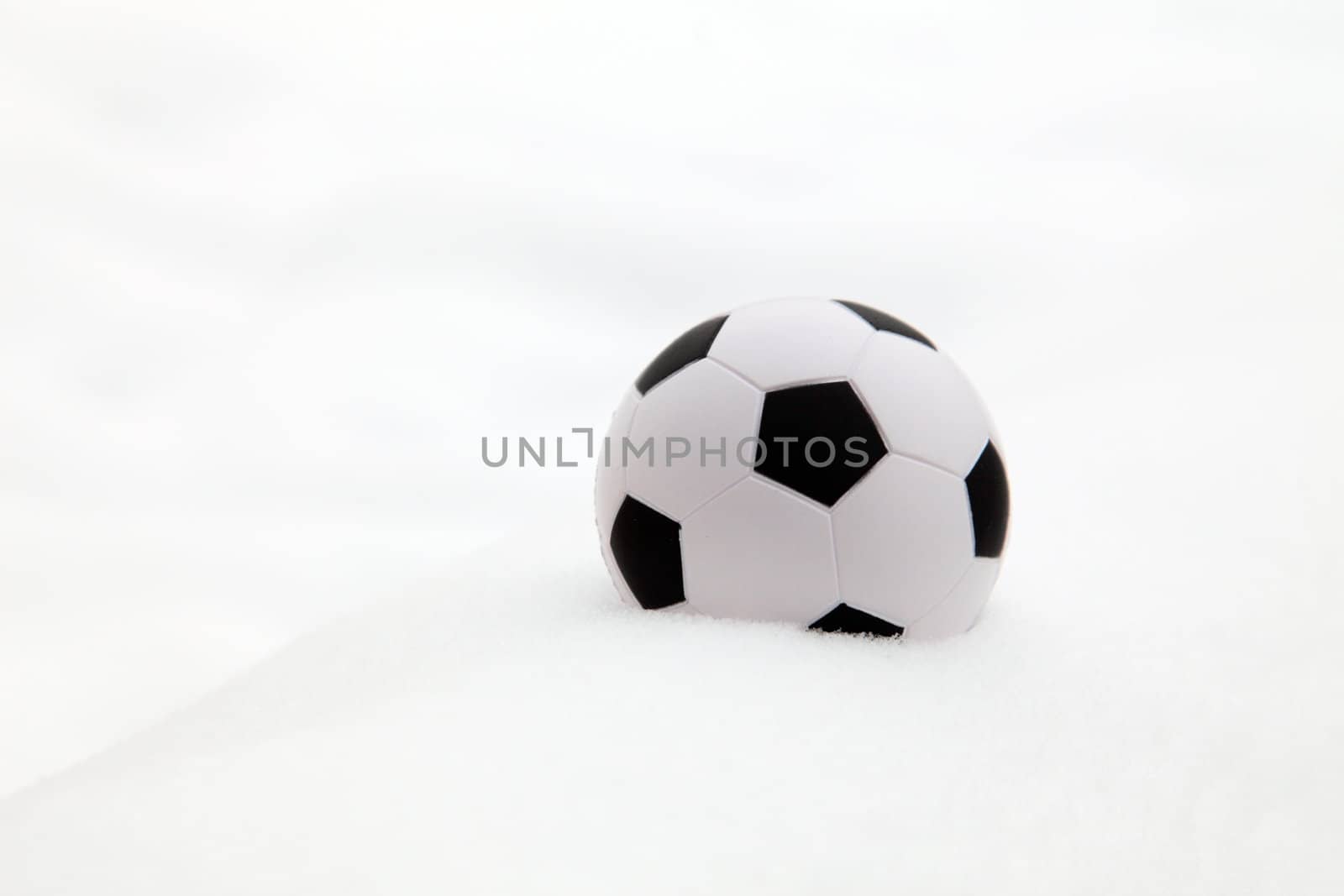 Soccer ball in the snow. All on white background.