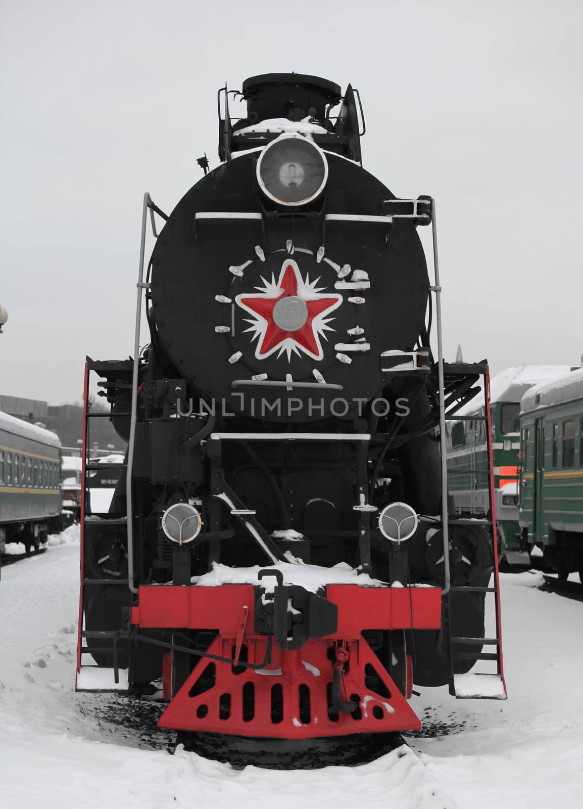 old Soviet locomotive at a train station in winter,  front view