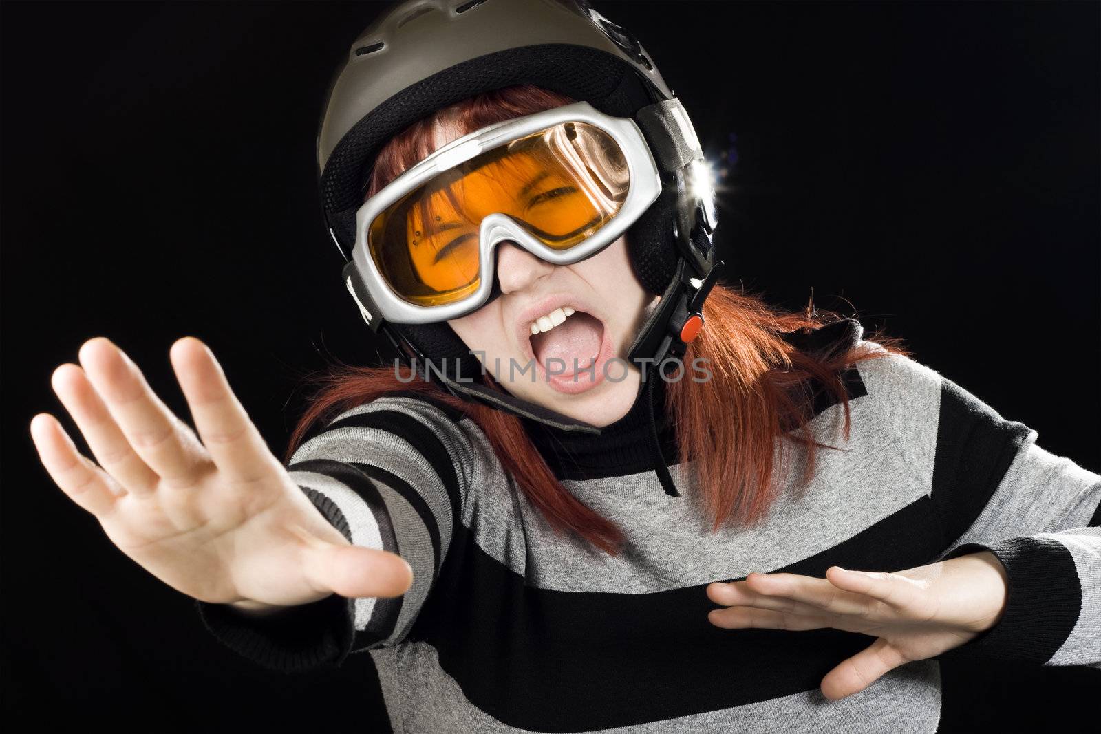 Girl wearing ski helmet and orange google and acting like she was snowboarding.

Studio shot.