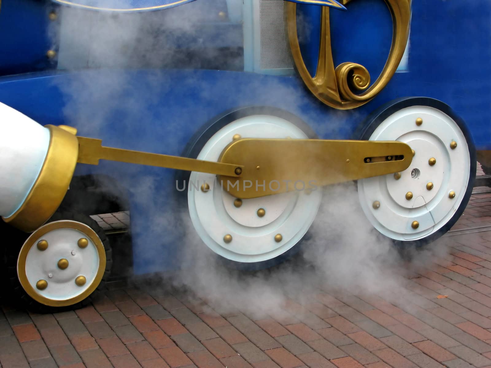 Train wheels with steam coming off of them.