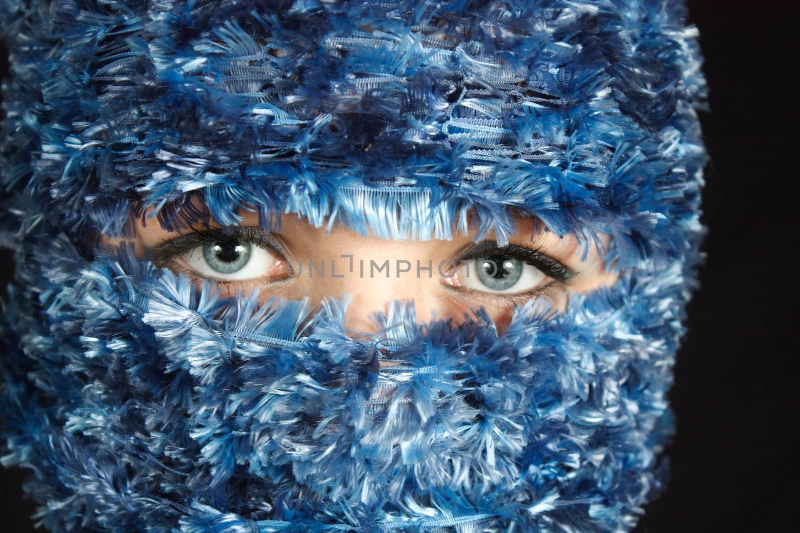 Pretty blue eyes is all that is showing through this blue veil wrapped around models face to highlight her eyes.