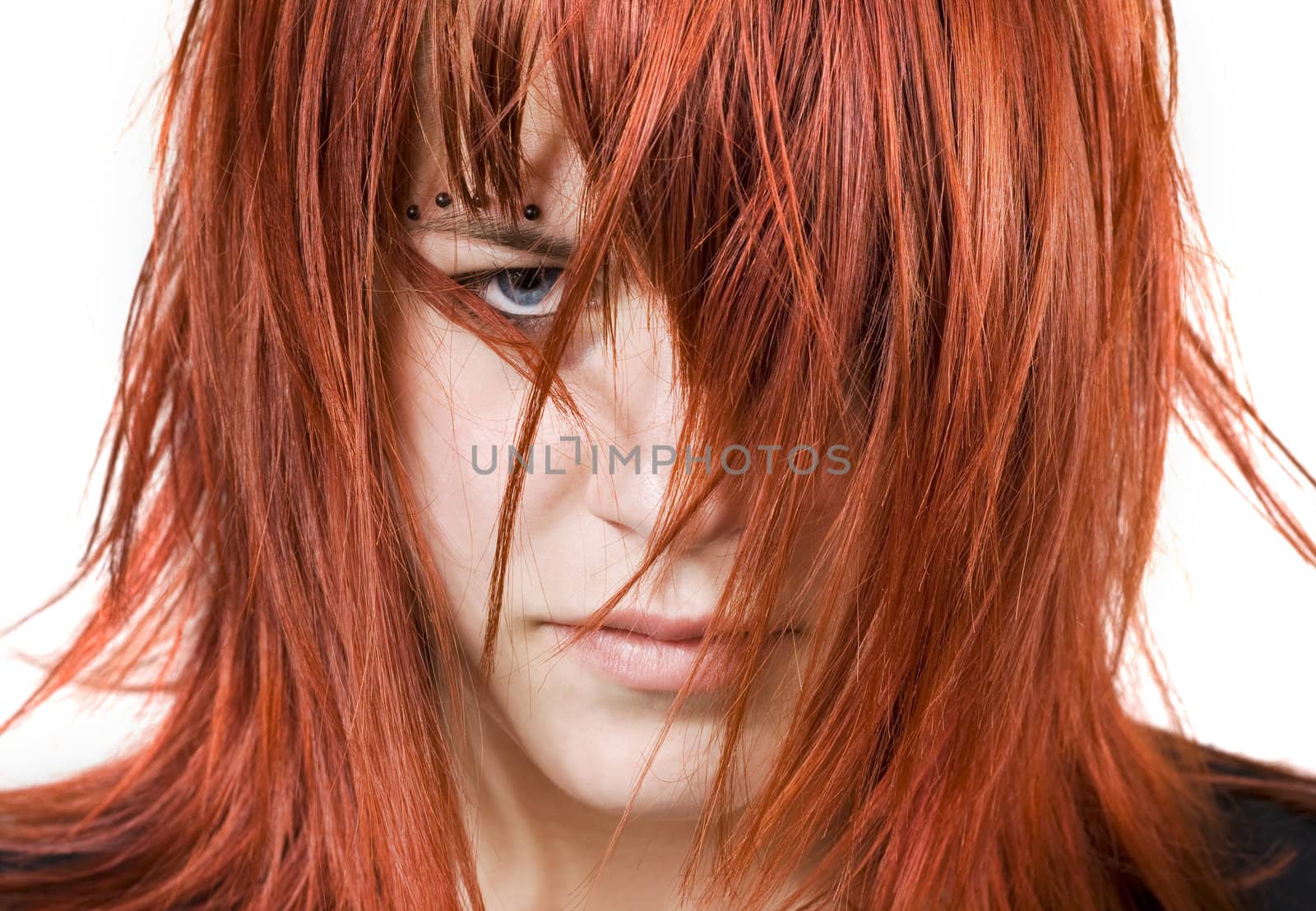 Cute redhead girl looking aggressively at the camera with messy or distressed hair.

Studio shot.