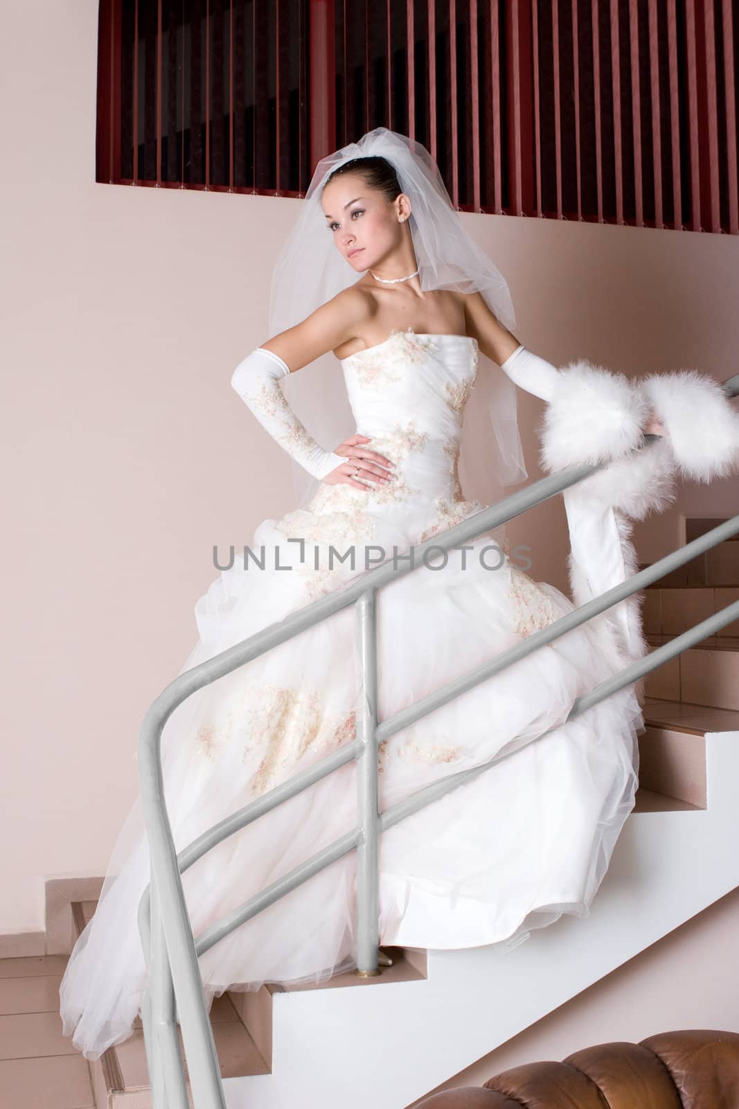 serious bride in a beautiful dress on the staircase